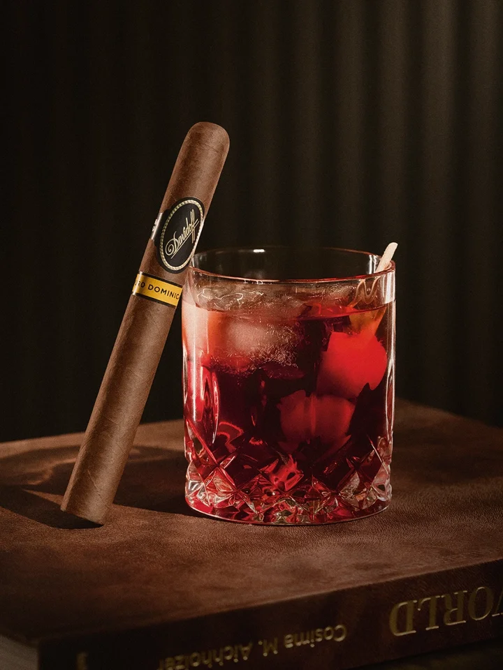 Cigar pairing with a Bourbon Old Fashioned: vanilla meets cappuccino notes. Sweet bourbon enhances leather and bittersweet chocolate flavors in an elegant, indulgent scene.