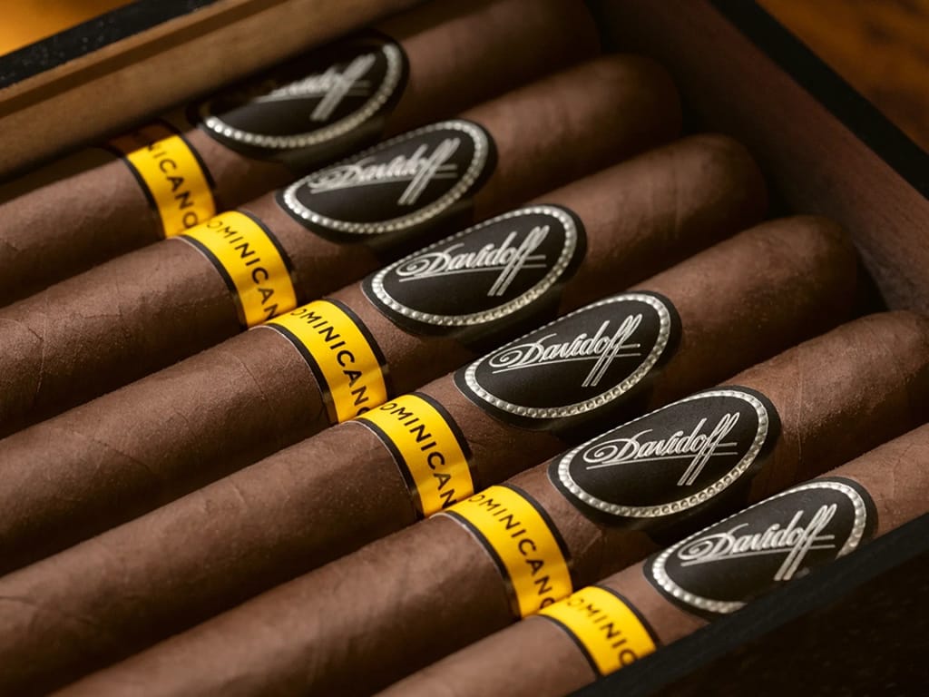 Close-up of a Davidoff Puro Dominicano cigar box with brown wrappers, black oval labels, and yellow “Dominican” bands, conveying luxury and sophistication.